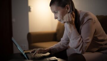 Barrierefreie Website: aeltere Frau bedient eine Website am Laptop